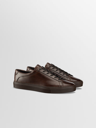 A pair of men's dark brown Italian leather lace-up dress sneaker shoes.