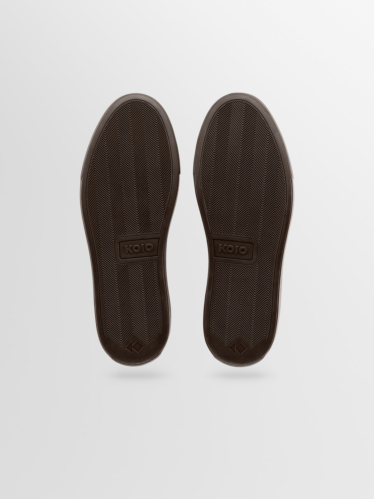 A pair of dark brown shoes shown from the sole view, featuring a textured tread pattern and the brand name 