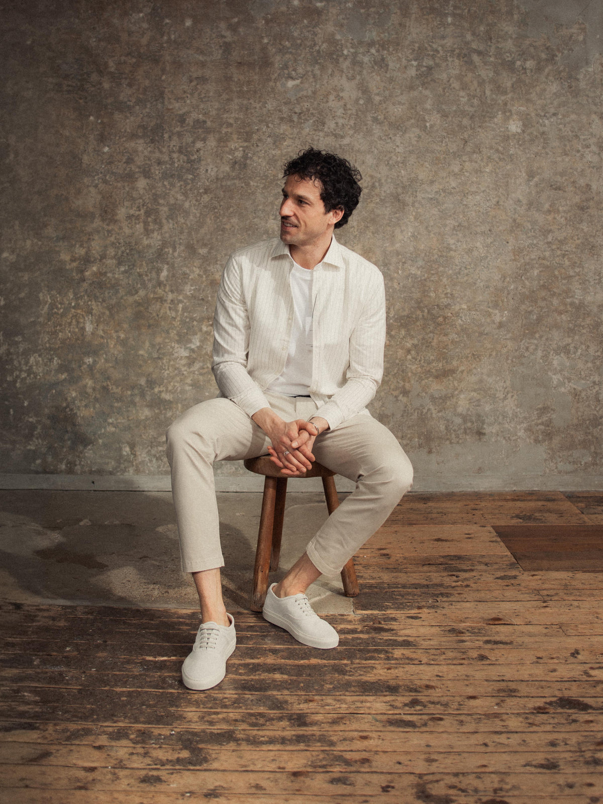 Man sitting on wooden stool wearing Men